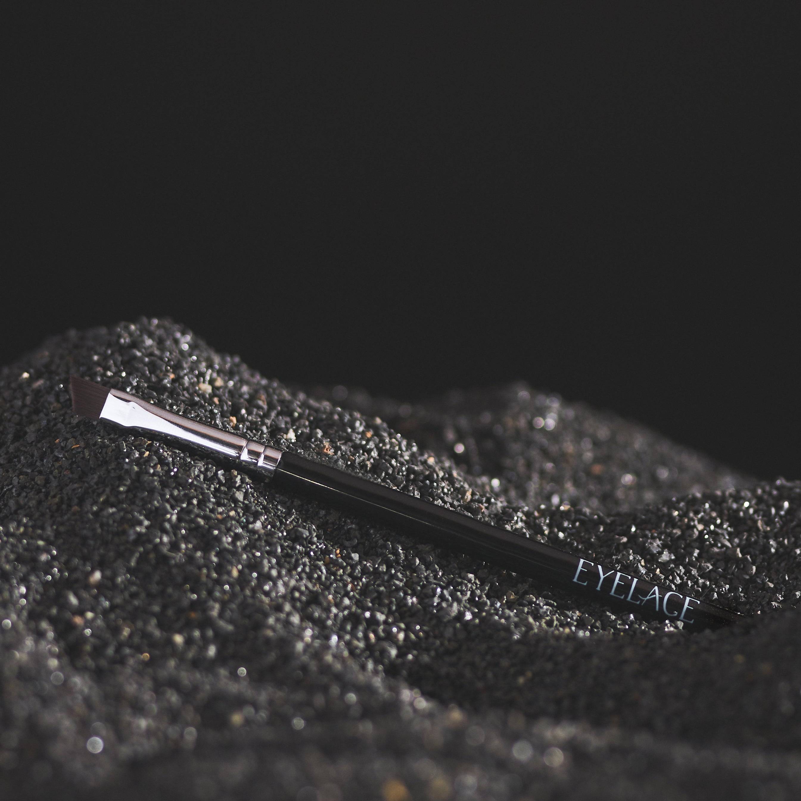 Eyelace Eyeliner Brush on textured black surface