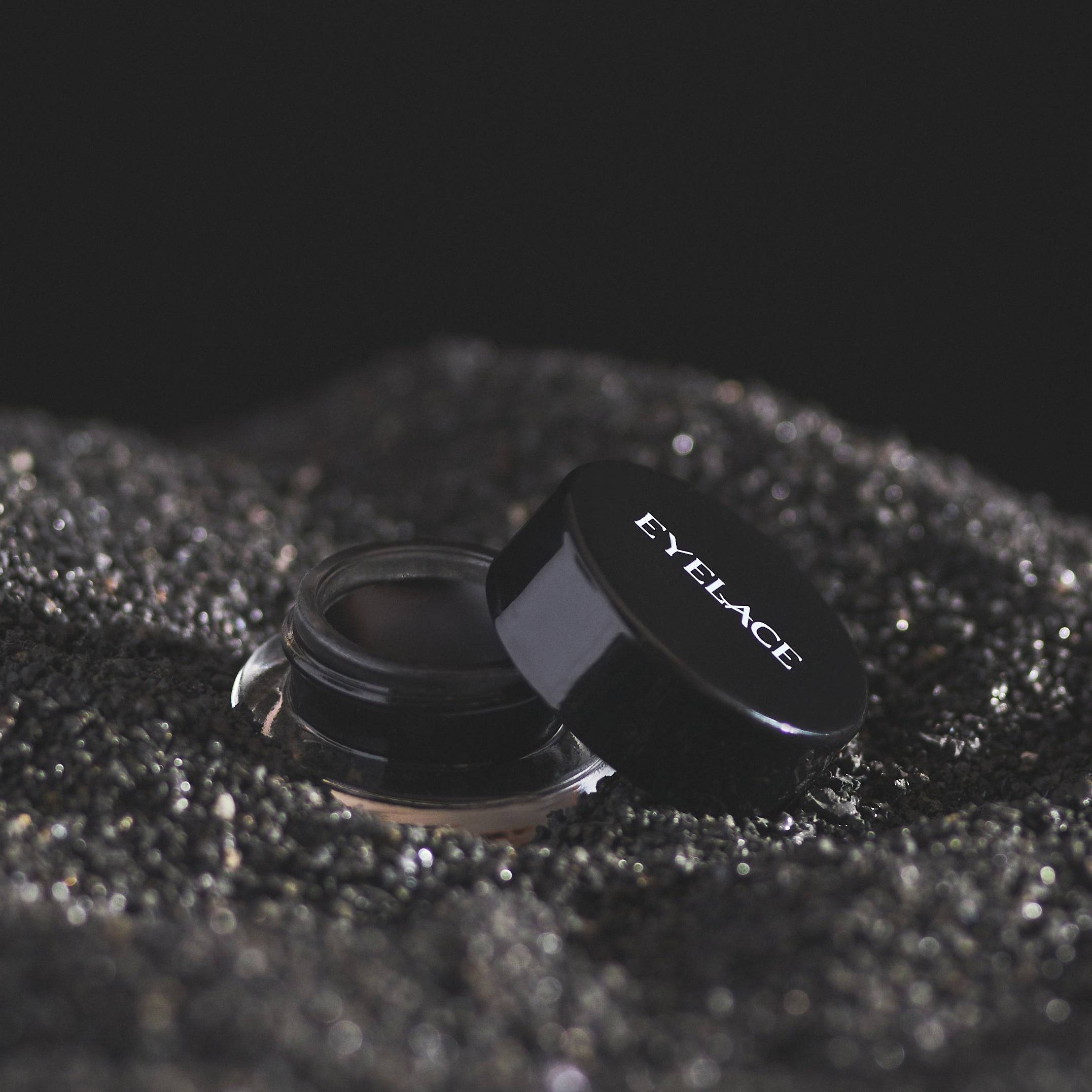 Eyelace Gel Eyeliner in black jar on textured surface